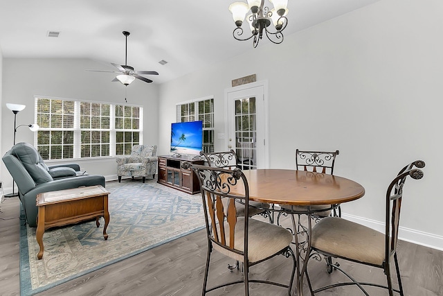 dining area featuring hardwood / wood-style flooring, ceiling fan with notable chandelier, and lofted ceiling