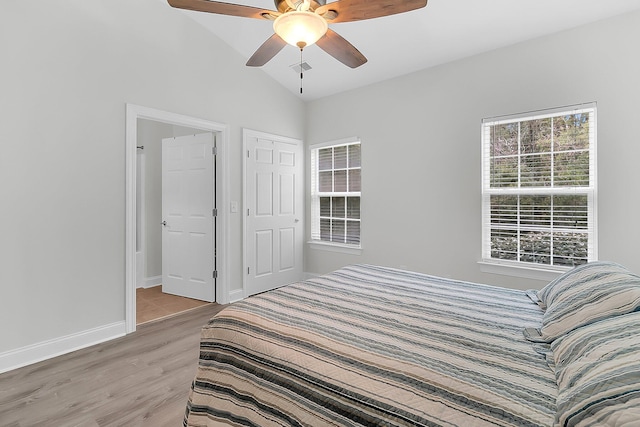 bedroom featuring light hardwood / wood-style floors, lofted ceiling, and ceiling fan