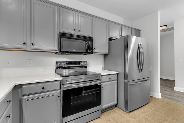 kitchen featuring stainless steel appliances, gray cabinets, and light tile patterned floors