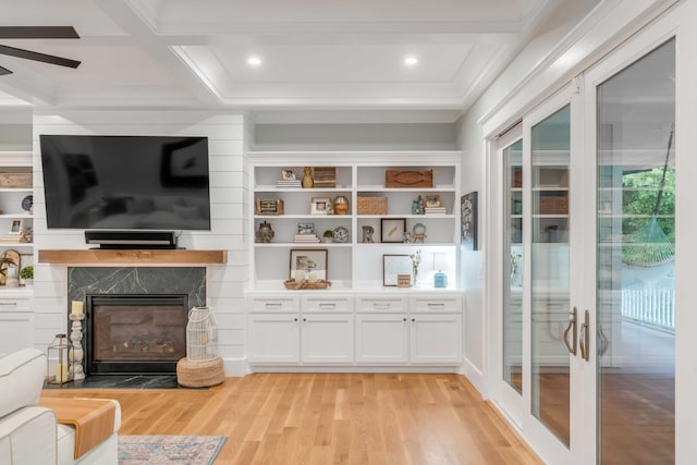 living room featuring ceiling fan, plenty of natural light, a high end fireplace, and light wood-type flooring