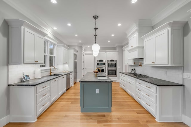 kitchen with white cabinetry, a kitchen island with sink, and backsplash