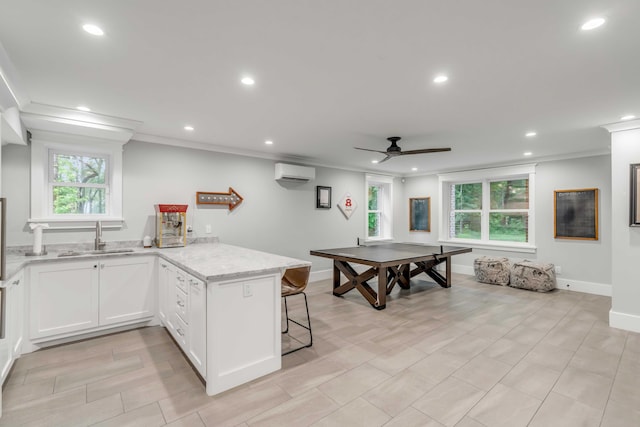 kitchen with an AC wall unit, plenty of natural light, ceiling fan, and kitchen peninsula