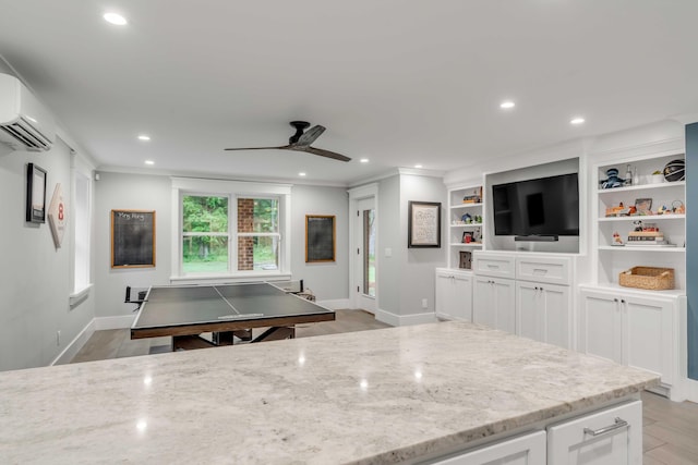 kitchen with light stone countertops, ceiling fan, light hardwood / wood-style flooring, and white cabinetry