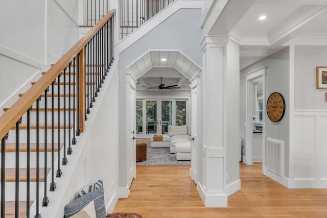 interior space featuring light hardwood / wood-style floors, crown molding, decorative columns, and ceiling fan