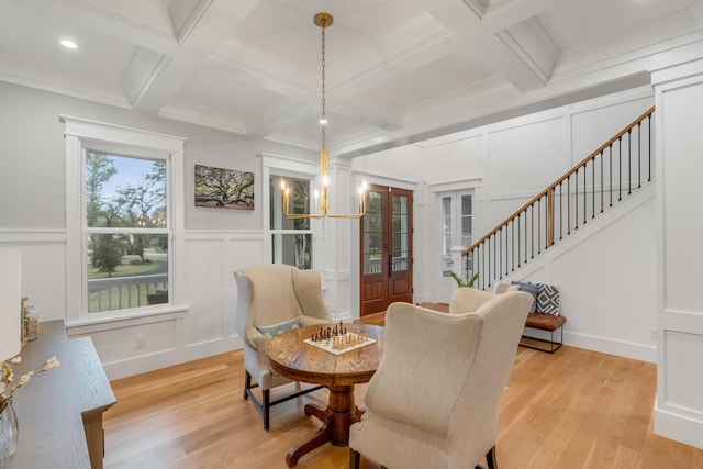 dining space featuring light hardwood / wood-style floors, coffered ceiling, and an inviting chandelier