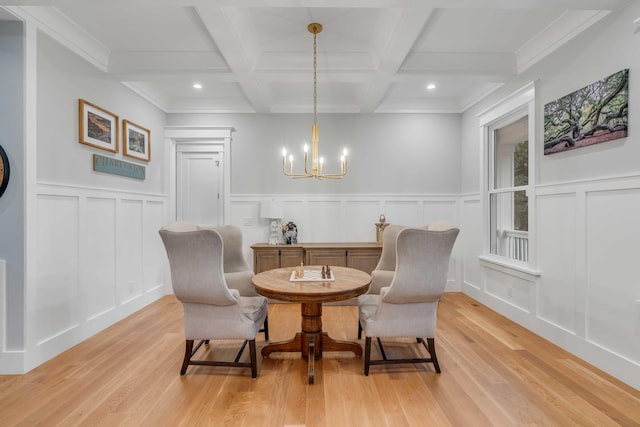 dining space with coffered ceiling, light hardwood / wood-style flooring, crown molding, and a notable chandelier