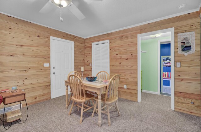 carpeted living room with wooden walls and ceiling fan