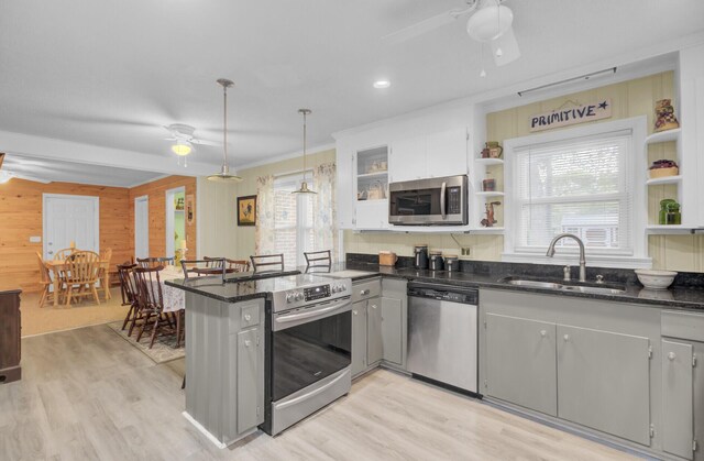 kitchen with hanging light fixtures, white cabinetry, kitchen peninsula, stainless steel appliances, and a kitchen bar