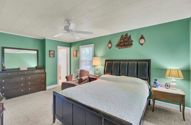 carpeted bedroom featuring ornamental molding, ceiling fan, and ensuite bathroom