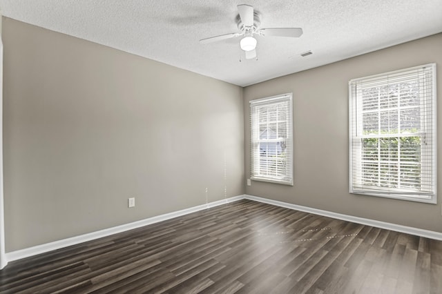 empty room with a ceiling fan, a textured ceiling, baseboards, and dark wood-style flooring