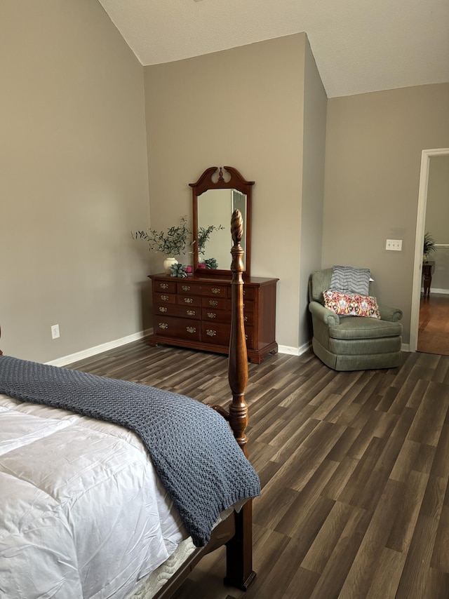 bedroom featuring lofted ceiling, baseboards, and wood finished floors