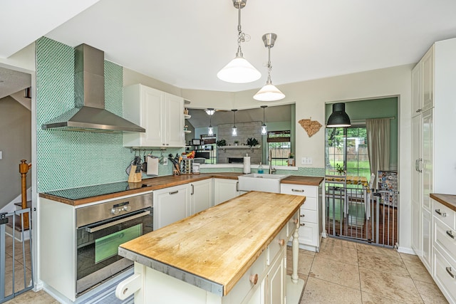 2650 Summer Leaves Ct, Charleston, SC 29414 - kitchen featuring stainless steel oven, wooden counters, wall chimney range hood, black electric cooktop, and tasteful backsplash