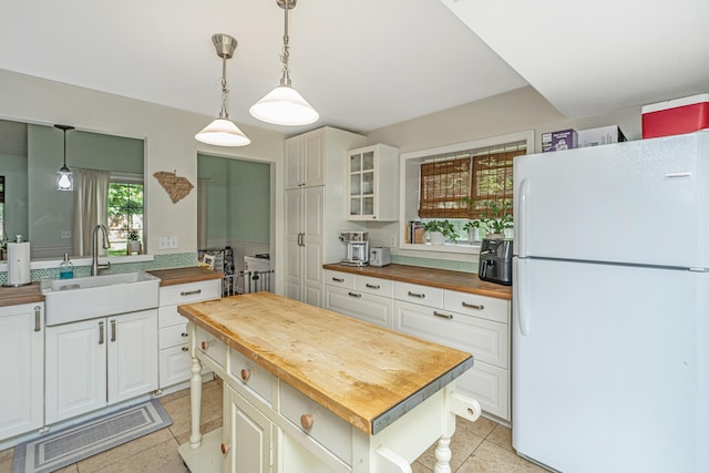 2650 Summer Leaves Ct, Charleston, SC 29414 - kitchen with wood counters, freestanding refrigerator, a sink, glass insert cabinets, and white cabinets