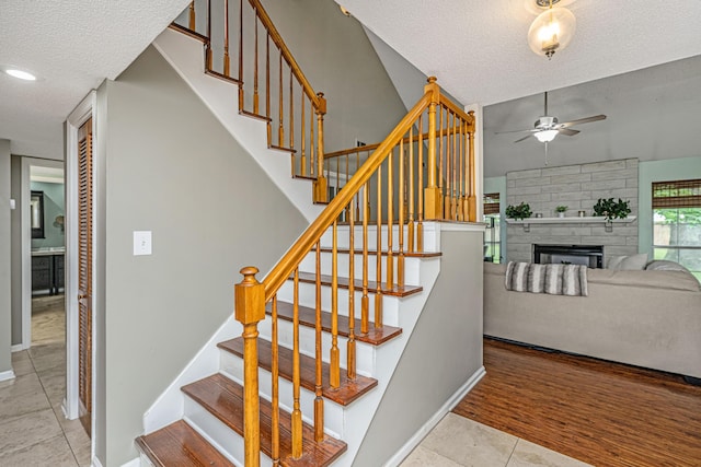 2650 Summer Leaves Ct, Charleston, SC 29414 - stairway with ceiling fan, a textured ceiling, baseboards, tile patterned floors, and a fireplace