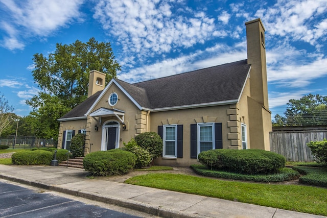 2650 Summer Leaves Ct, Charleston, SC 29414 - view of front facade with a chimney, stucco siding, uncovered parking, and a shingled roof