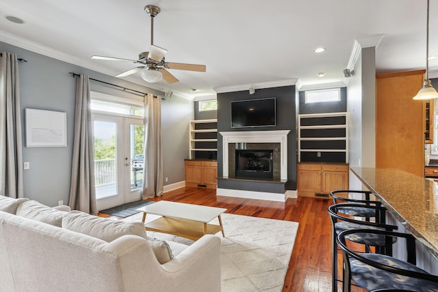 living room featuring crown molding, dark hardwood / wood-style flooring, ceiling fan, and french doors