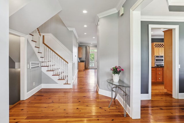 foyer entrance with hardwood / wood-style floors and ornamental molding