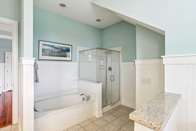 bathroom featuring tile patterned flooring, vaulted ceiling, and shower with separate bathtub