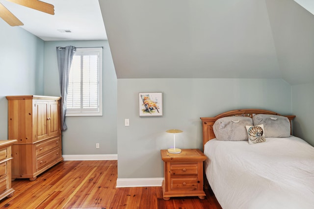 bedroom with vaulted ceiling, light hardwood / wood-style flooring, and ceiling fan