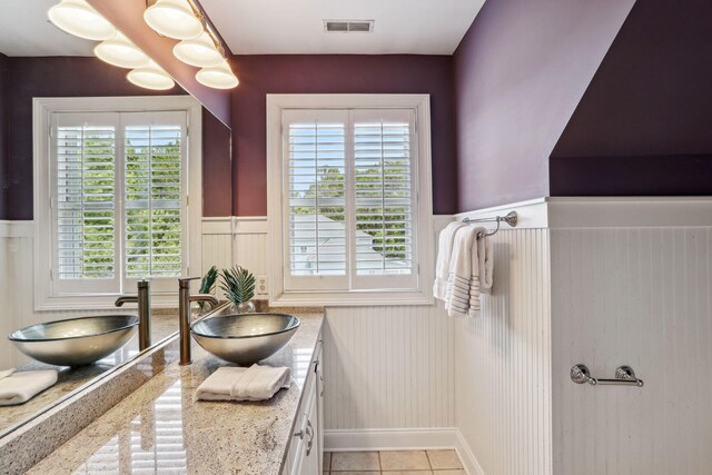 bathroom with tile patterned floors, vanity, and a healthy amount of sunlight