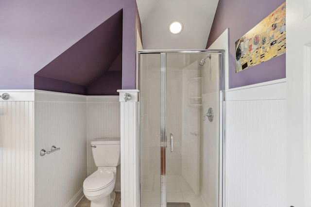 bathroom with toilet, tile patterned floors, vaulted ceiling, and a shower with shower door