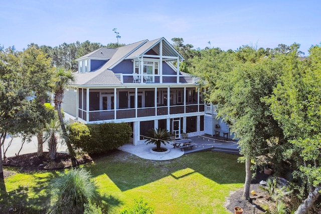 back of property with a yard, a patio, and a sunroom