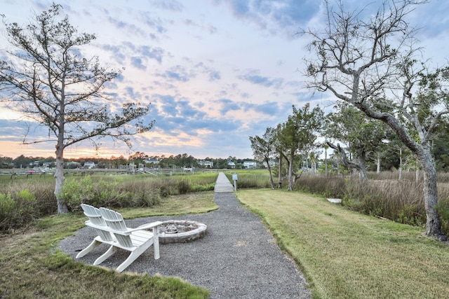 yard at dusk featuring an outdoor fire pit