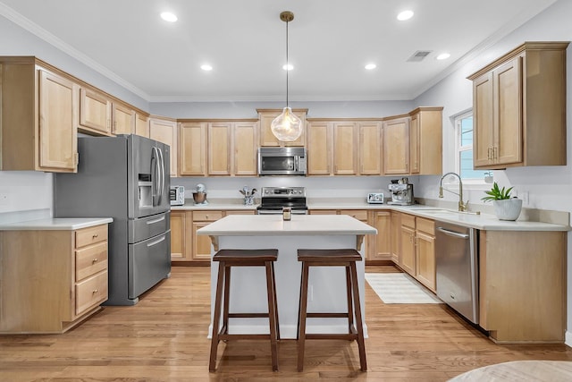 kitchen with appliances with stainless steel finishes, light brown cabinets, light hardwood / wood-style floors, and sink