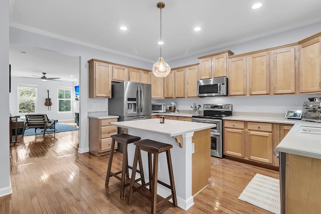 kitchen featuring a kitchen bar, appliances with stainless steel finishes, light hardwood / wood-style floors, and ceiling fan