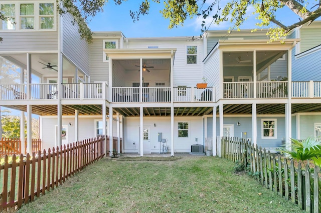 back of property with a sunroom, a yard, ceiling fan, and central air condition unit