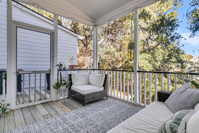 sunroom / solarium featuring a healthy amount of sunlight and vaulted ceiling