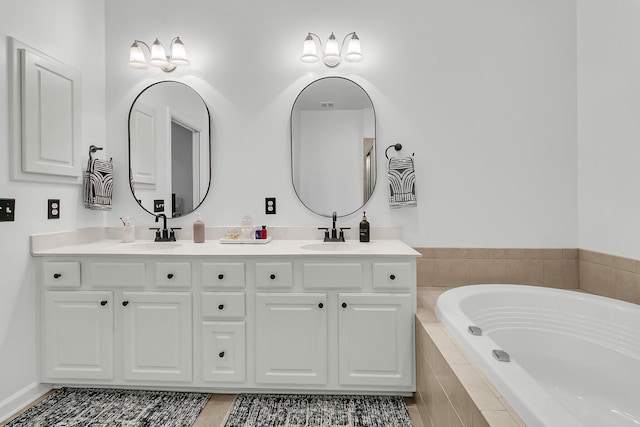 bathroom featuring vanity and tiled bath