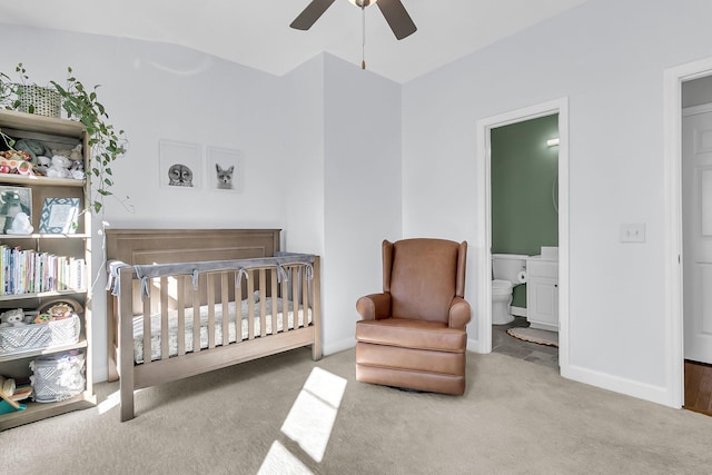 bedroom featuring connected bathroom, ceiling fan, a nursery area, and light carpet