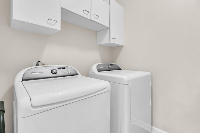 washroom featuring washer and dryer and cabinets