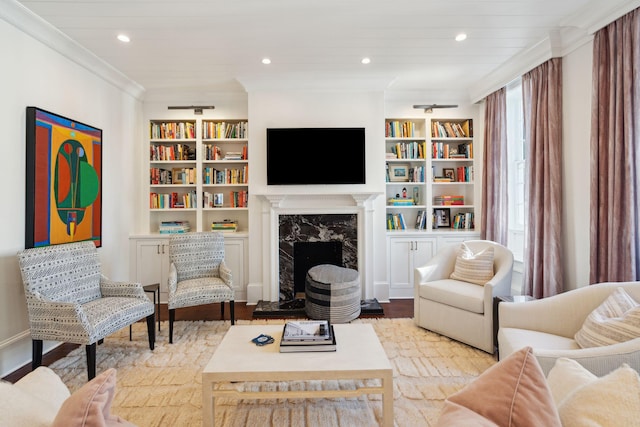 living room with crown molding, built in features, a high end fireplace, and light hardwood / wood-style flooring