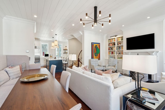 living room featuring wood ceiling, hardwood / wood-style flooring, a notable chandelier, ornamental molding, and built in shelves