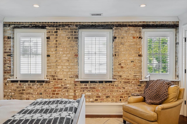 living area featuring brick wall