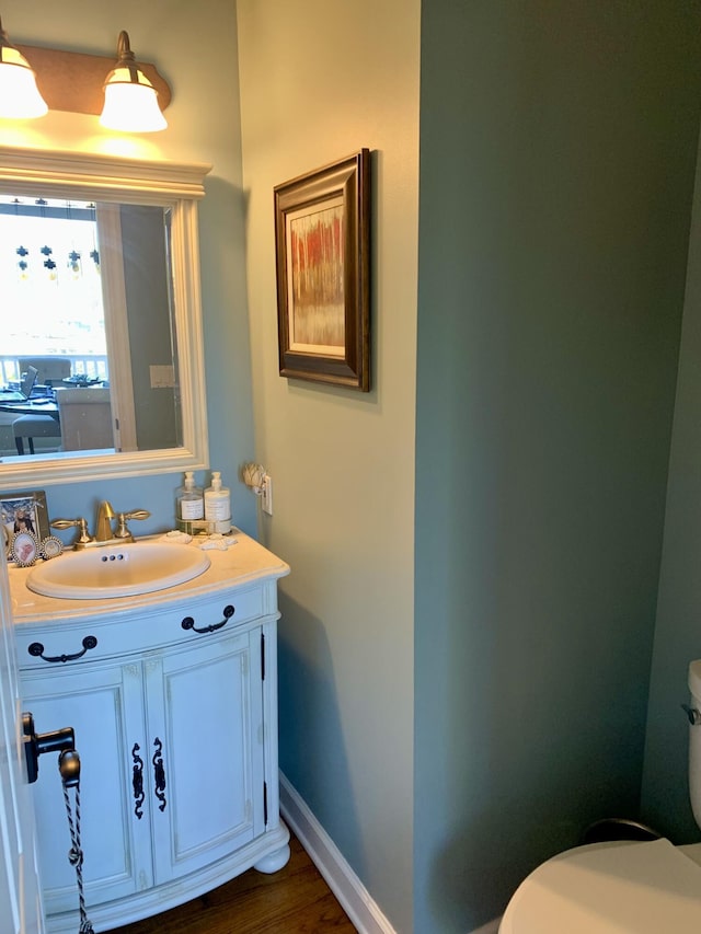 bathroom featuring toilet, wood-type flooring, and vanity