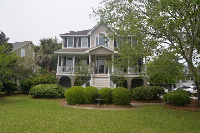 colonial home featuring a porch and a front lawn