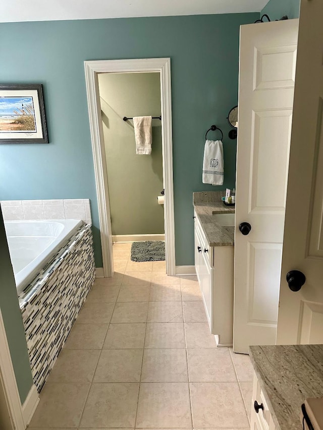 bathroom featuring vanity, tile patterned floors, and tiled bath