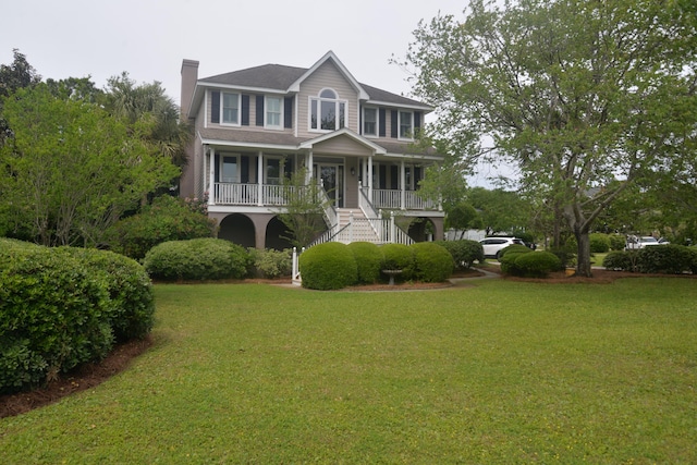 colonial home with a front yard and a porch