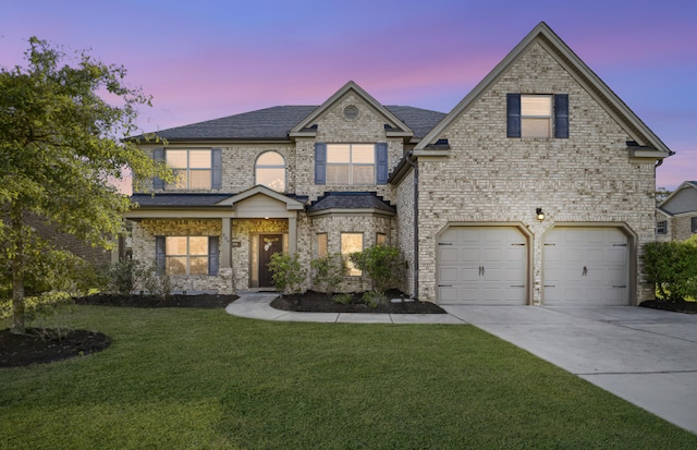 view of front of home with a garage and a yard