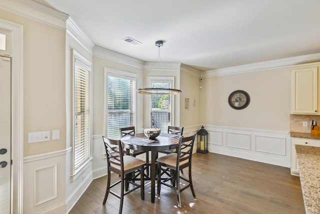 dining room featuring ornamental molding, a notable chandelier, and dark hardwood / wood-style floors