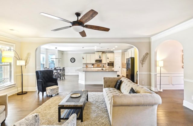 living room featuring dark hardwood / wood-style flooring, ceiling fan, a wealth of natural light, and ornamental molding