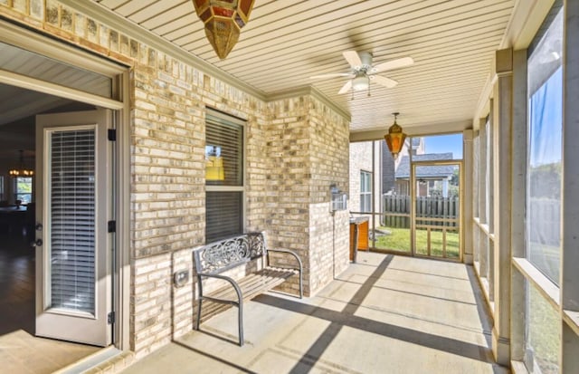 unfurnished sunroom with ceiling fan