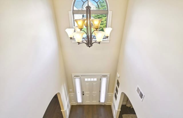 entryway featuring a high ceiling, a chandelier, and dark hardwood / wood-style flooring