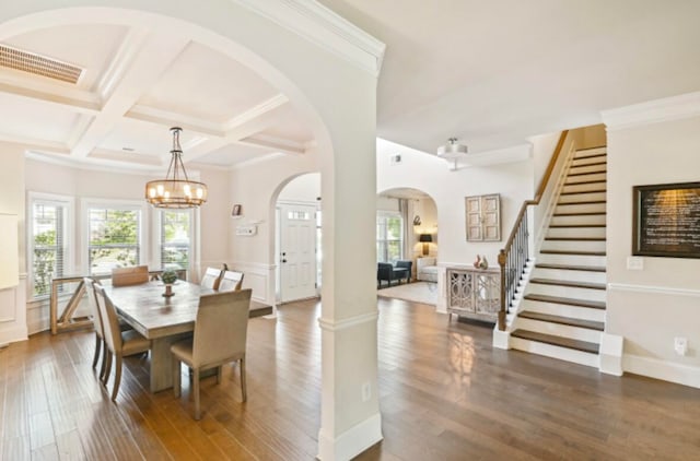 dining room with coffered ceiling, dark wood-type flooring, a chandelier, beamed ceiling, and crown molding