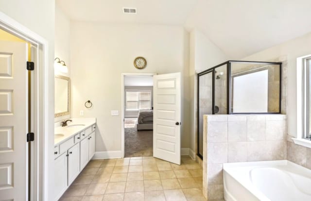 bathroom with tile flooring, a wealth of natural light, independent shower and bath, and dual bowl vanity