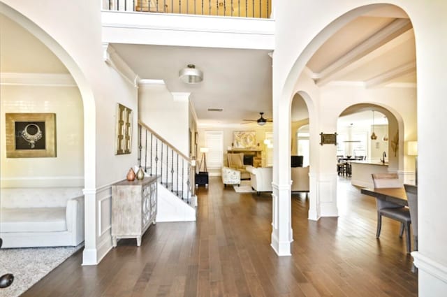 foyer featuring ceiling fan, crown molding, and dark wood-type flooring