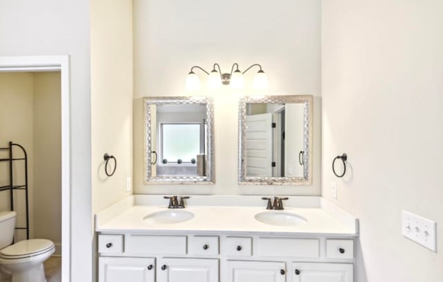 bathroom featuring double sink, oversized vanity, and toilet